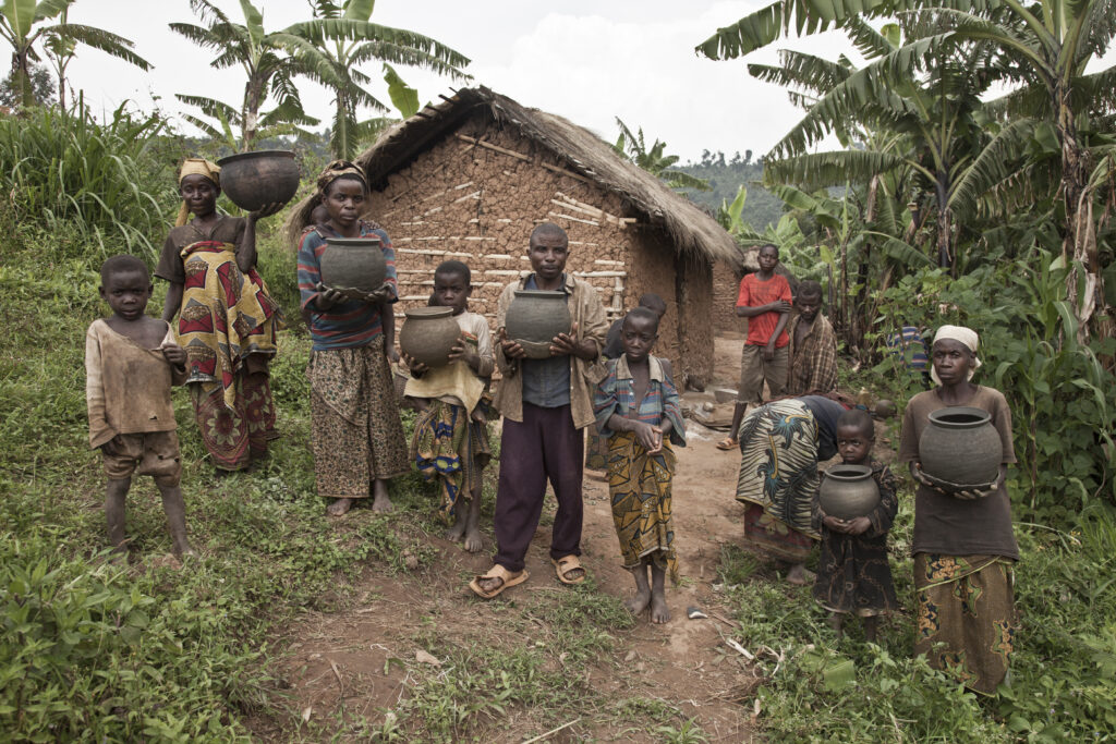 Rural family proudly standing outside their home with agricultural produce